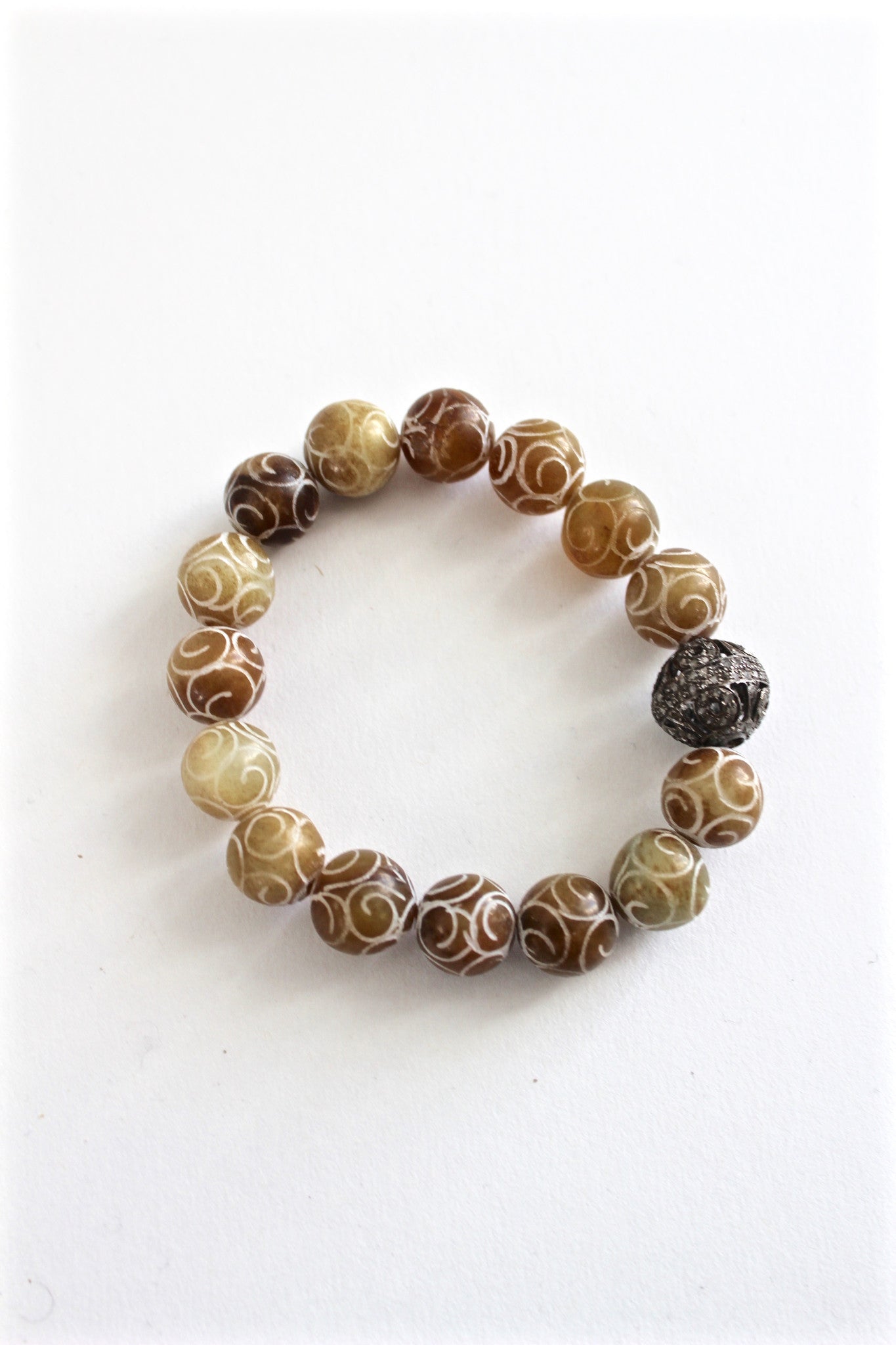 carved bead bracelet with diamond bead